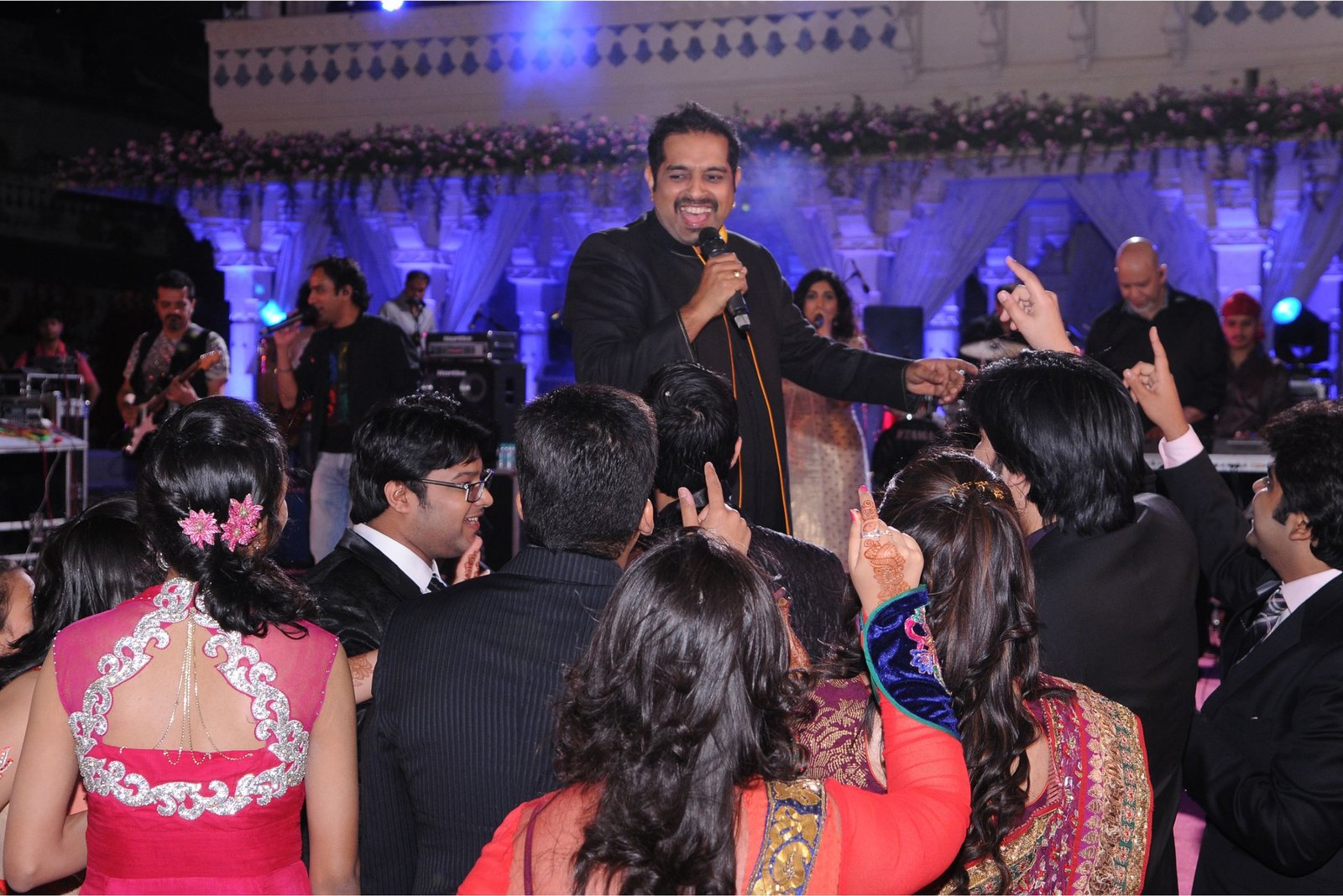 Group of men posing with large cartoon character inflatable figures at night outdoors